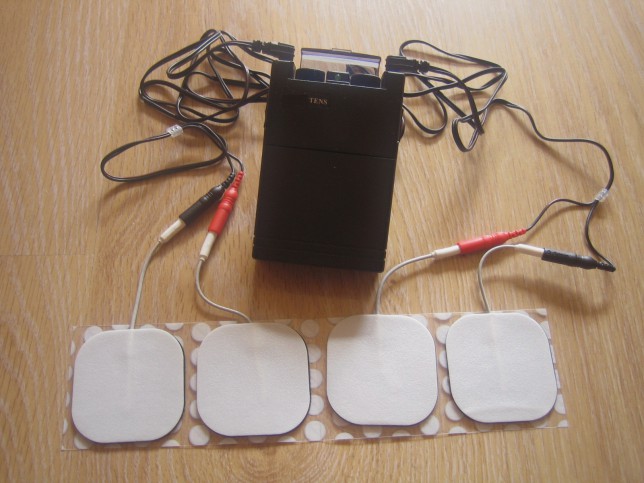 Appareil d'électrothérapie (TENS) relié à 4 électrodes
